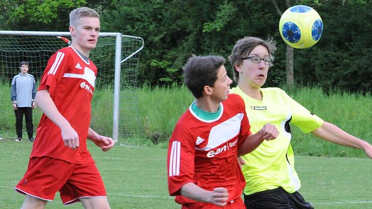 Schulter an Schulter: Ins Kopfball-Duell gehen der Hammelburger Immanuel Giesewetter (rechts) und Thundorfs Jannik Scheuring. Aufmerksamer Beobachter ist SG-Kicker Stefan Guthardt. Foto: Hopf