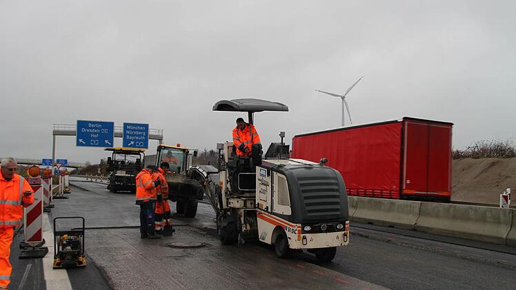 Die Grunderneuerung der A70 steht kurz vor dem Abschluss. Unser Bild zeigt Bauarbeiter bei Asphaltierungsarbeiten im Mittelstreifen kurz vor dem Autobahndreieck Bayreuth/Kulmbach. Im Hintergrund ist das Windrad bei Altenreuth zu sehen. Foto: Alexander Hartmann