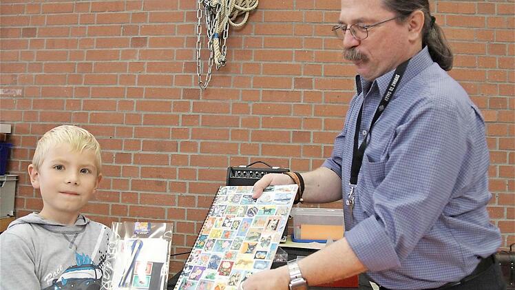 Maximilian tauscht die Blaue Mauritius vom Wühltisch gegen ein Briefmarkensortiment von Roland Full ein.