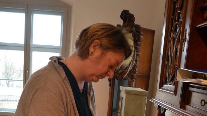 Annette Schäfer mit dem Fotoalbum von Pater Sales Heß, das den Bauverlauf der Sassanfahrter Pfarrkirche dokumentiert Foto: Andrea Spörlein