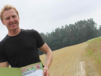 Links der Roggen, rechts die Wildkräuter: Landwirt Gerhard Kerschbaum auf der Ackerschutzfläche bei Hemhofen.