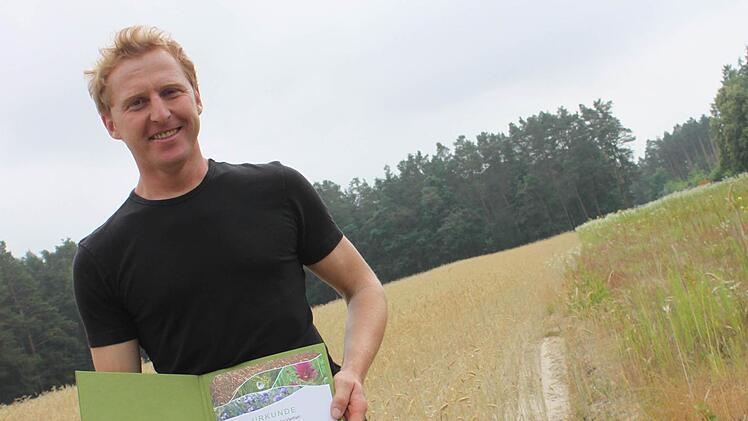 Links der Roggen, rechts die Wildkräuter: Landwirt Gerhard Kerschbaum auf der Ackerschutzfläche bei Hemhofen.