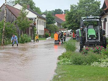 In Salmsdorf mühten sich viele Helfer, um die Folgen entlang der Hauptstraße einzudämmen.Foto: Ralf KestelIn Salmsdorf mühten sich viele Helfer, um die Folgen entlang der Hauptstraße einzudämmen.Foto: Ralf Kestel