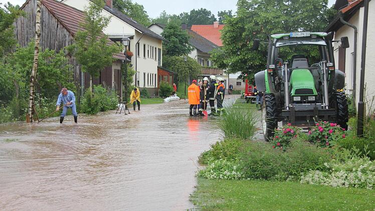 In Salmsdorf mühten sich viele Helfer, um die Folgen entlang der Hauptstraße einzudämmen.Foto: Ralf KestelIn Salmsdorf mühten sich viele Helfer, um die Folgen entlang der Hauptstraße einzudämmen.Foto: Ralf Kestel