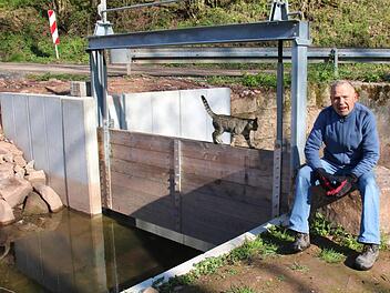 Johannes Full hat sein Interesse für Wasserräder und historische Wehre bei einer Reise in den Vinschgau entdeckt. Nun kann er seine Ideen an der Aschacher Oberen Mühle umsetzen. Hier sitzt er an dem erneuerten Wehr, das den Zulauf des Mühlkanals reguliert. Foto: K. Kupka-Hahn