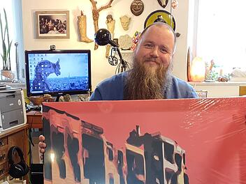 Thomas Seuberling mit einem seiner Werke. Im Hintergrund ist das wichtigste Utensil seiner Kunst erkennbar: der Computer. Darüber: Skurrile Fundstücke, die die unverwechselbare Dekoration in seiner Wohnung ausmachen. Foto: Susanne Will