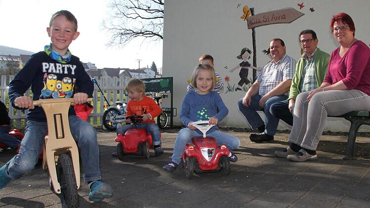 Toben auf dem Hof: Die Kinder der Kita St. Anna bekommen bald eine frisch sanierte Kita. Vorher müssen sie allerdings umziehen. Carola Martin (von rechts) und Reinhard Müller vom Trägerverein sowie Bürgermeister Bernold Martin organisieren das Ganze. Foto: Ulrike Müller