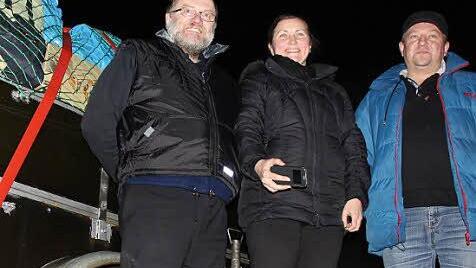 Priester Bogdan Puszkar (von links), Olena Albert und ein ukrainischer Fahrer vor dem Spendenanhänger in Hausen.  Foto: Benedikt Borst
