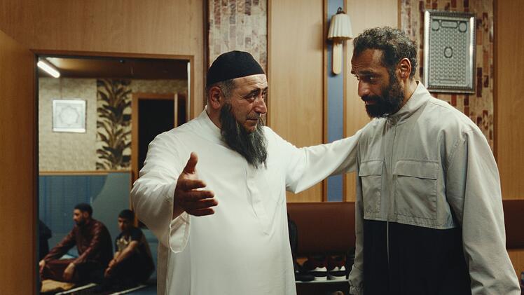 Undercover-Staatsschutz-Mietarbeiter Murat Cem (Tamer Trasoglu, rechts) wird vom Prediger Emin Simsek (&Ouml;zg&uuml;r Karadeniz) empfangen.