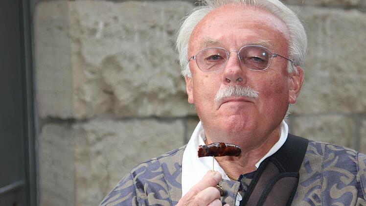 Helmut Zuber führt kulinarisch durch die Stadt. Hier testet er eine Bratwurst der Metzgerei Kraus.  Fotos: Corinna Igler