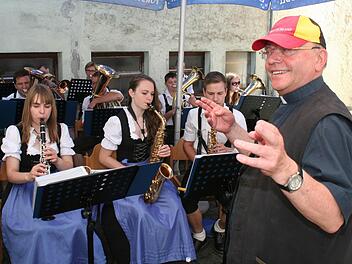 Pater Stefan zeigte sich als Fan der deutschen Fußball-Nationalmannschaft und ließ es sich nicht nehmen, die Blaskapelle bei einem Stück zu dirigieren. Foto: Evi Seeger