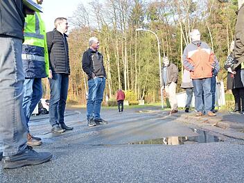 Pfützen, hier auf der Brücke über den Krebsbach in Spittelstein, zeigen den Mitgliedern des Bausenats bei ihrer Besichtigungsfahrt Schäden an den Straßen im Stadtgebiet. Foto: Rainer Lutz