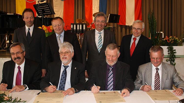 Die vier Bürgermeister der Allianz "Kissinger Bogen" hatten im April die Urkunde unterzeichnet (von links): Günter Kiesel (Nüdlingen), Wolfgang Back (Bad Bocklet), Waldemar Bug (Burkardroth) und Gotthard Schlereth (Oberthulba) mit (hinten, von links) Baudirektor Joachim Mair (ALE), Landrat Thomas Bold, Otmar Porzelt (AfL) und Jürgen Jäger (Regierung von Unterfranken).  Foto: Archiv/Angelika Luga-Braun