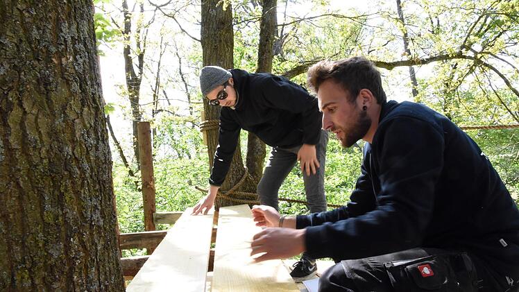 Nico (hinten) und Heiko Ehrenberger tüftel am Baumhaus auf dem Festivalgelände in Dormitz. Foto: Christoph Wiedemann