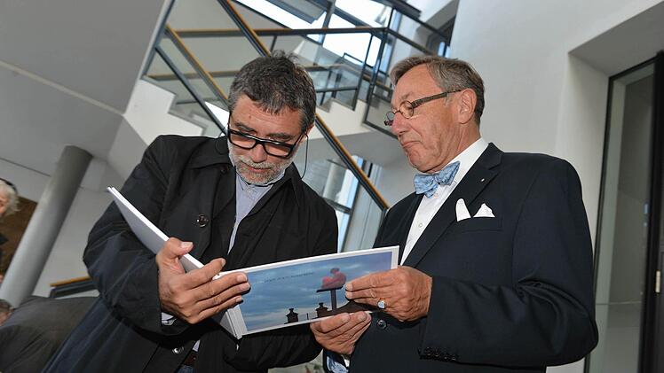 Jaume  Plensa betrachtet die von Bernd  Goldmann (rechts) herausgegebene Dokumentation seiner Ausstellung.