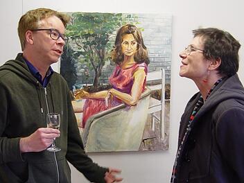 Nach der offiziellen Eröffnung der Ausstellung ergaben sich anregende Gespräche. Wie es scheint, beteiligt sich auch die Dame auf dem Gemälde an der Szenerie. Foto: Brigitta Kempe-Wolf