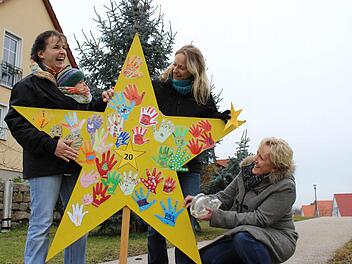 Letzte Vorbereitungen: Gemeinsam kleben Kathrin Fischer mit Sohnemann Ludwig, Verena Amendt und Peggy Knauer die letzten Handabdrücke an den Stern an.Foto: Nina Grötsch