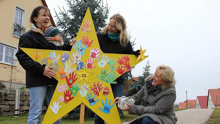 Letzte Vorbereitungen: Gemeinsam kleben Kathrin Fischer mit Sohnemann Ludwig, Verena Amendt und Peggy Knauer die letzten Handabdrücke an den Stern an.Foto: Nina Grötsch