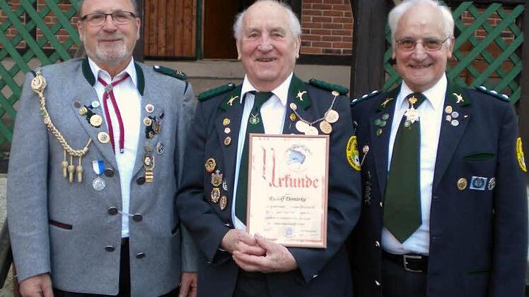 Für seine jahrzehntelange Arbeit auf vielen Ebenen wurde Rudolf Dominka (Mitte) vom Zweiten Gauschützenmeister Otto Iff (links) und Schützenmeister Joseph Borschert (rechts) mit der Vereinsehrennadel in Gold mit Kranz ausgezeichnet.