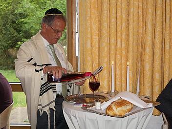 Fritz Schroth lud zur Shabbatfeier im Rahmen der Israeltagung ein. Das Bild zeigt wie er den Segen über Brot und Wein spricht.   Marion Eckert