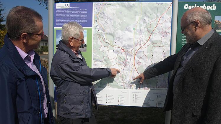 Vier neue Rundwege verlaufen im und durch das Gemeindegebiet. Die Routen entstanden über die Allianzen im Landkreis Schweinfurt, darunter Oberes Werntal mit Oerlenbach. Vor Ort engagierten sich Werner Dengler (links) und Reinhold Zwirlein (Mitte), die zusammen mit Bürgermeister Franz Kuhn die Touren auf der Infotafel am Bahnhaltepunkt Oerlenbach betrachten. Foto: Stefan Geiger