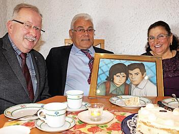 Ali und Emsal Coban mit Bürgermeister Friedrich Gleitsmann und einem Bild von ihrer Silberhochzeit Foto: Evi Seeger