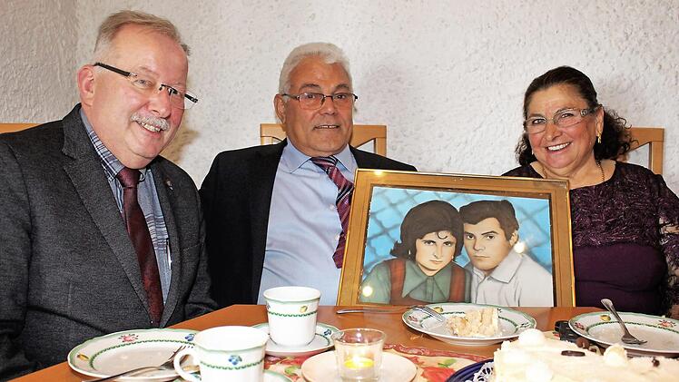 Ali und Emsal Coban mit Bürgermeister Friedrich Gleitsmann und einem Bild von ihrer Silberhochzeit Foto: Evi Seeger