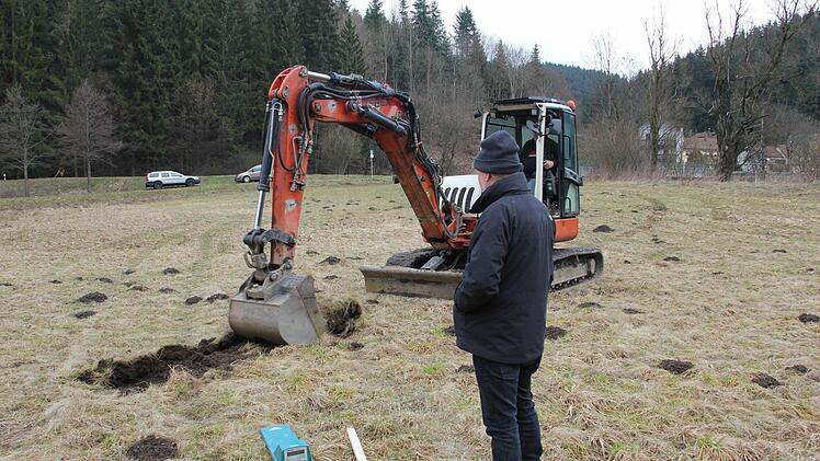 Thomas Röckel beobachtet "den ersten Spatenstich" für das Staubecken der Wallenfelser Flößer. Mit dem Metallsuchgerät (türkis) hatte er vorher gecheckt, dass keine Leitung durch die Wiese verläuft.