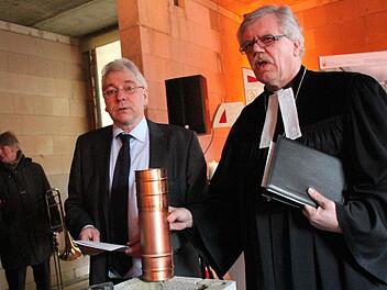 Richard Winkler und Rektor Hermann Schönauer (v. l.) bestücken die Zeitkapsel mit Urkunde, Angaben zum Bauprojekt, Tageszeitungen und Münzen.  Foto: Josef Hofbauer