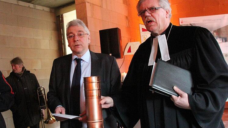 Richard Winkler und Rektor Hermann Schönauer (v. l.) bestücken die Zeitkapsel mit Urkunde, Angaben zum Bauprojekt, Tageszeitungen und Münzen.  Foto: Josef Hofbauer