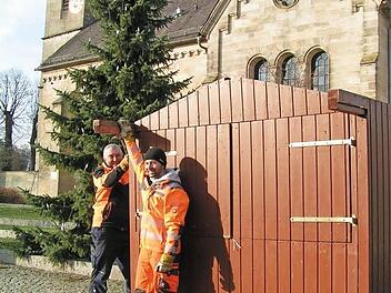 Die beiden Bauhofmitarbeiter Gerhard Hofmann (links) und Andreas Lang bauen die erste Holzbude vor der St.-Anna-Kirche auf. Foto: Heid Amon