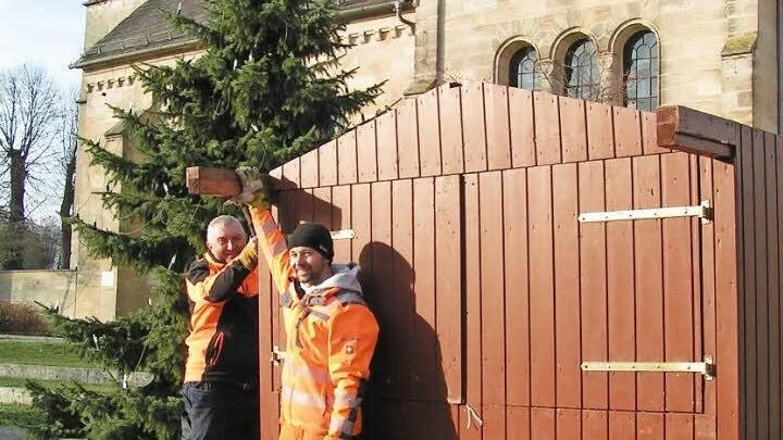 Die beiden Bauhofmitarbeiter Gerhard Hofmann (links) und Andreas Lang bauen die erste Holzbude vor der St.-Anna-Kirche auf. Foto: Heid Amon