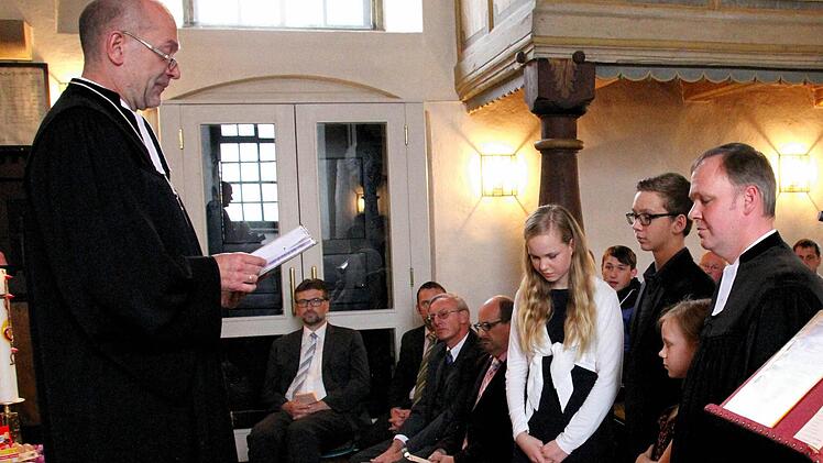 Dekan Johannes Grünwald (links) entpflichtet Pfarrer Till Roth aus seinen Diensten; daneben dessen Kinder Renate, Benedikt und Katharina (von rechts). Foto: Thomas Micheel