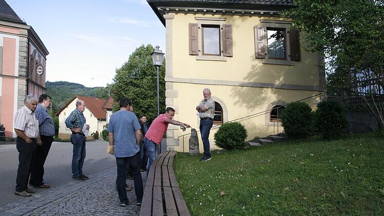 Wenig Platz gibt es am Rugendorfer Dorfplatz für ein Buswartehäuschen. Möglicherweise wäre ein Glasbau in den Hang zurückversetzt eine Lösung, wie Gemeinderat Gerhard Theuer bei einem Ortstermin andeutete. Foto: Klaus Klaschka