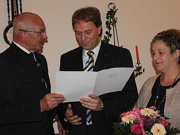 Bezirkstagspräsident Günther Denzler (links) zeichnet den Steinbacher Bürgermeister Klaus Löffler (Mitte) aus. Mit im Bild Löfflers Ehefrau Silke.  Foto: Veronika Schadeck