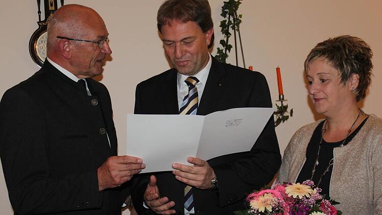 Bezirkstagspräsident Günther Denzler (links) zeichnet den Steinbacher Bürgermeister Klaus Löffler (Mitte) aus. Mit im Bild Löfflers Ehefrau Silke.  Foto: Veronika Schadeck