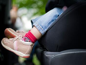 M&auml;dchen sitzt in einem Kindersitz im Auto