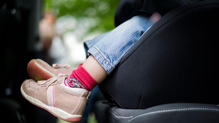 M&auml;dchen sitzt in einem Kindersitz im Auto