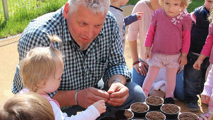 Stadtgärtner Johannes Lindner erklärt den Kindern, was die Sonnenblume besonders macht. Fotos: Carmen Schmitt