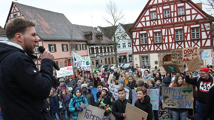 David Komann, einer von vier Organisatoren, spricht zu den Teilnehmern: "Tauscht Euch aus! Nervt Eure Eltern jeden Tag!" Unten: Plakativer Zug der Schüler zum Marktplatz  Fotos: Bernhard Panzer