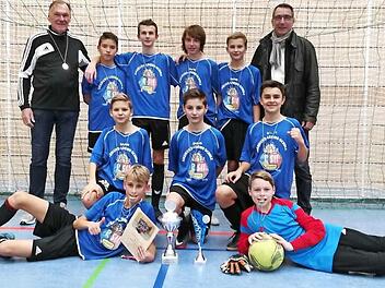 Das siegreiche Team pr&auml;sentierte nach der Siegerehrung stolz den Wanderpokal - (stehend von links) Coach Dr. Jochen Forkel, Tim Wachter (3), Niklas Wich (3), Felix Geigerhilk (3), Konstantin Mayr (6), Direktor Uwe Sch&ouml;nfeld, (kniend von links) Luca Peter (1), Luis Deckelmann, Johannes Sch&uuml;tz (2), (vorne von links) Oliver Schubert (6) und TW Benjamin Rang. In Klammern die jeweils erzielten Tore  Foto: Heike Sch&uuml;lein