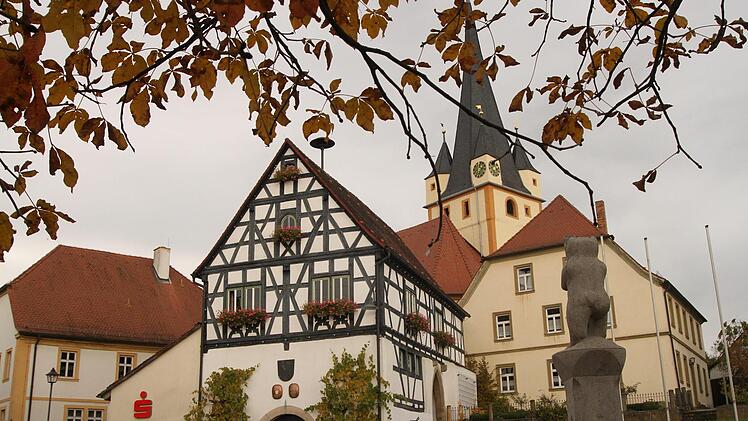 Der "Stettfelder Bär" am Dorfbrunnen hat seinen Blick auf die "gute Stube" von Stettfeld gerichtet mit dem alten Rathaus, der Pfarrkirche Mariä Himmelfahrt und dem Pfarrhaus. Foto: Günther Geiling