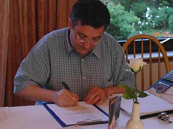 Pfarrer Michael Krammer setzt als erster sein Signum unter die modifizierte Satzung des Kapellenbauvereins Speicherz e.V.  Foto: Stephanie Elm