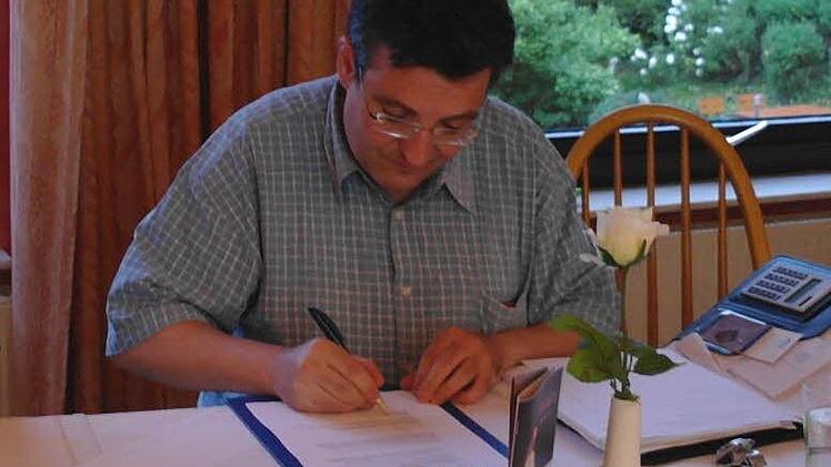 Pfarrer Michael Krammer setzt als erster sein Signum unter die modifizierte Satzung des Kapellenbauvereins Speicherz e.V.  Foto: Stephanie Elm