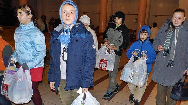 Mit ihren Geschenken verlassen die Kinder mit ihren Eltern das Gotteshaus in Budapest. Foto: Thea Höhn