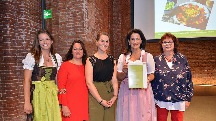 Eine Urkunde als Belohnung: Gwendolin Hammer (Amt für Ernährung, Landwirtschaft und Forsten Würzburg), Isabell Cicero (Haus für Kinder), Leonie Horn (Verpflegungsbeauftragte, Haus für Kinder), Michaela Kaniber (Ernährungsministerin) und Renate Kröckel (Kindergartenleiterin). Foto: StMELF/Astrid Schmidhuber
