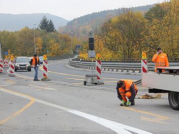 Arbeiter entfernen die gelben Fahrbahnmarkierungen an der Kronacher Südbrücke.  Fotos: Friedwald Schedel