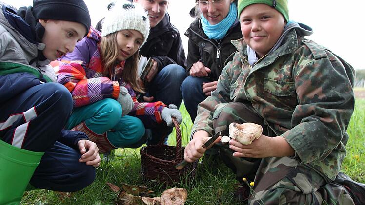 Auf Pilzsuche: Daniel (von links), Jessica und Noah sind gerne in der Natur unterwegs. Heike Gögelein und Nils-Constantin Haupt (beide hinten) passen auf, dass nichts Giftiges im Korb landet. Foto: Ulrike Müller