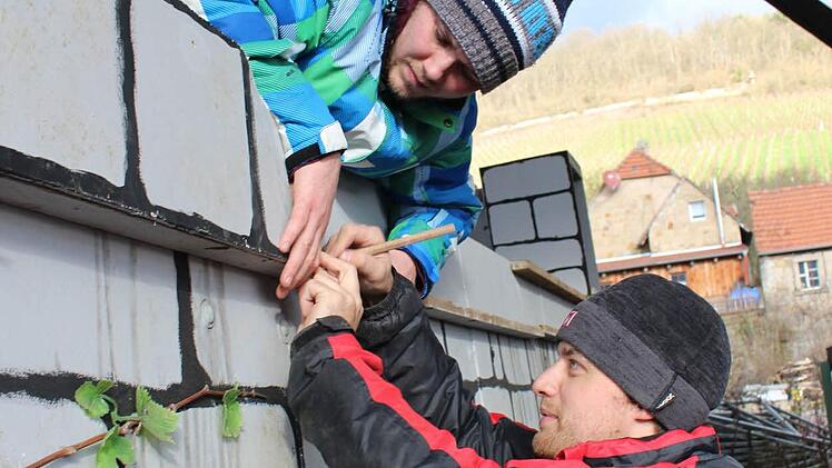 Ziegelanger: Sascha Harth (rechts) markiert die Stellen, an die später die Holzbretter angebracht werden. Foto: Mattheus