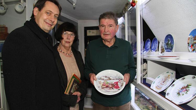 Bürgermeister Roland Wolfrum sowie Franziska und Alfred Neupert zeigen seltene Weihnachtsteller. Foto: Sonny Adam